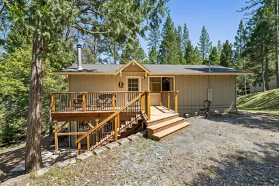 a tiny house with a porch and a deck at The Cozy Cabin - 2-Level Home with Spacious Yard home in Groveland
