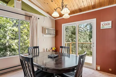 a dining room with a table and chairs and windows at The Cozy Cabin - 2-Level Home with Spacious Yard home in Groveland