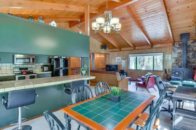 a kitchen and living room with a table and chairs at Cozy Cabin in Pine Mountain Lake Near Yosemite! in Groveland