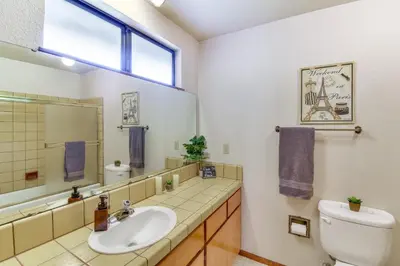 a bathroom with a sink and a toilet and a window at Cozy Cabin in Pine Mountain Lake Near Yosemite! in Groveland