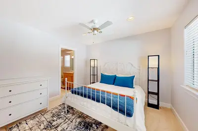 a white bedroom with a bed and a ceiling fan at Andria Grove in Stateline
