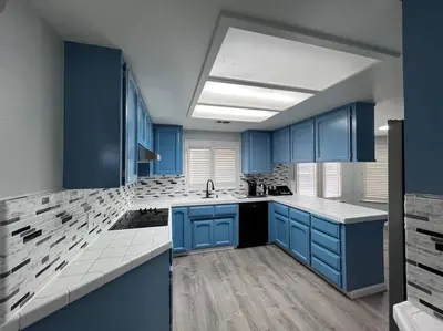 a blue kitchen with a sink and blue cabinets at Entire 3 BR & 2 BA house for business and family in Modesto