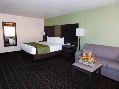 a hotel room with a bed and a couch at Travelodge by Wyndham Angels Camp CA in Angels Camp