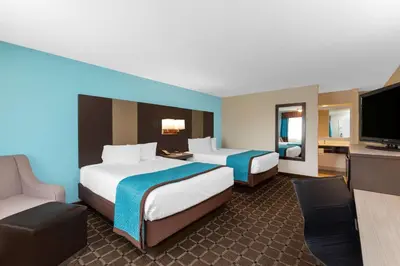 a hotel room with two beds and a flat screen tv at Travelodge by Wyndham Angels Camp CA in Angels Camp