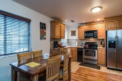 a kitchen with a wooden table and a stainless steel refrigerator at Spring Wonderland in Yosemite West