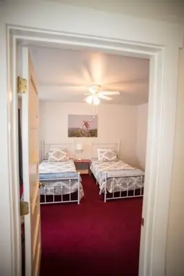 a room with two beds and a ceiling fan at Yosemite Firehouse Inn in Mariposa