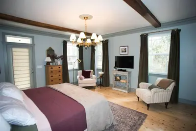 a bedroom with a bed and two chairs and a television at Yosemite Firehouse Inn in Mariposa
