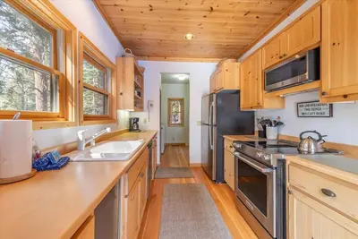 a kitchen with wooden cabinets and a black refrigerator at Cozy Designer Decorated Cabin Near Slopes Fireplace Peekaboo Lakeview in Carnelian Bay
