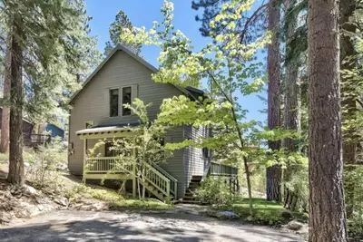 a house in the woods with a driveway at Cozy Designer Decorated Cabin Near Slopes Fireplace Peekaboo Lakeview in Carnelian Bay