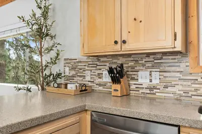 a kitchen with wooden cabinets and a counter top at Cozy Yosemite Family Retreat-13mi to South Gate in Oakhurst