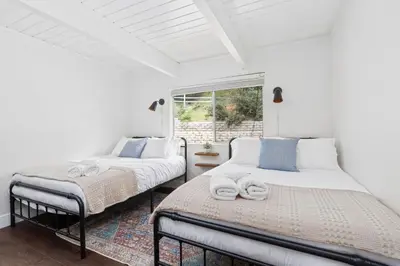 two beds in a room with a window at Cozy Yosemite Family Retreat-13mi to South Gate in Oakhurst