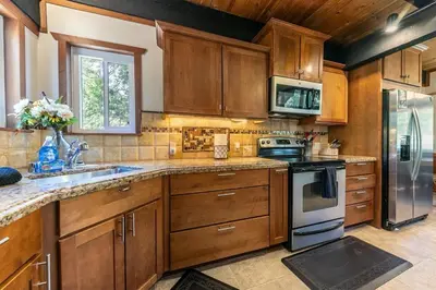 a kitchen with wooden cabinets and a sink and a stove at Carnelian Bay 4BD Near Beach & Slopes in Carnelian Bay