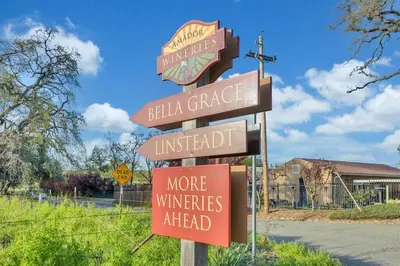 a street sign with many signs on a pole at Lakeside Vineyard Retreat - Deaver's Winery in Plymouth