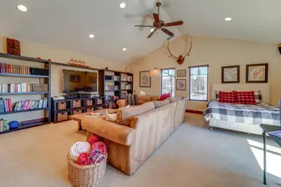 a living room with a couch and bookshelves at Private Patio and Gas Grill Stunning Truckee Home in Truckee