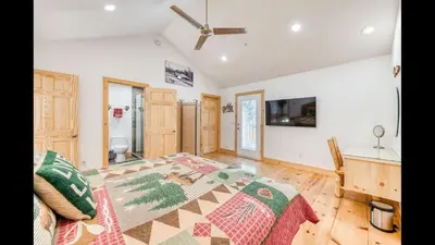 a bedroom with a large bed and a desk at #2 Cottage Like Suite With Private Hot Tub in Bass Lake