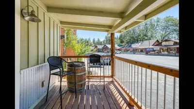 a porch with two chairs and a view of a street at #2 Cottage Like Suite With Private Hot Tub in Bass Lake