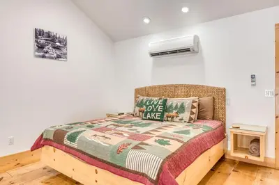 a bedroom with a bed with a blanket at #4 Cottage Like Suite with Private Hot Tub in Bass Lake