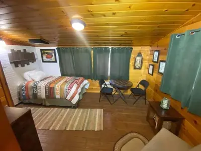 a bedroom with a bed and a table and chairs at Knotty Pines Lodge in Bass Lake Annex