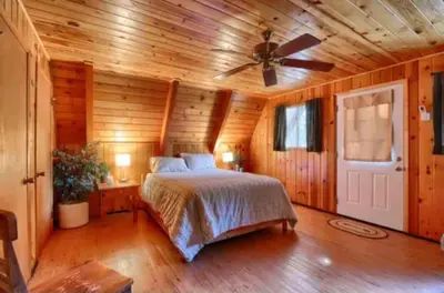 a bedroom with a bed and a ceiling fan at Knotty Pines Lodge in Bass Lake Annex