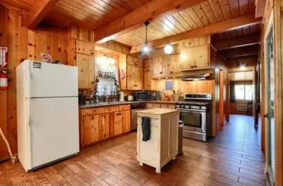 a kitchen with a white refrigerator and wooden cabinets at Knotty Pines Lodge in Bass Lake Annex