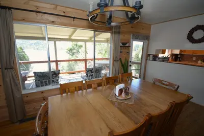 a dining room with a wooden table and a large window at Fox Lake View in Bass Lake