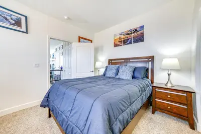 a bedroom with a bed and a table with a lamp at WWII Aviation-Themed Apt in Sparks Near Parks! in Sparks
