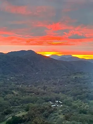 a sunset over the mountains with the sun setting at Mystic Mountain Retreat in Miramonte