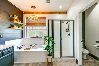 a bathroom with a tub and a shower and a window at Enchanting Clovis Haven with Hot Tub and Private Pool! in Clovis