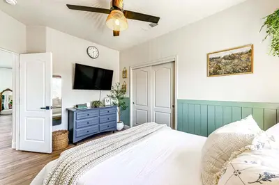 a bedroom with a bed and a flat screen tv at Enchanting Clovis Haven with Hot Tub and Private Pool! in Clovis