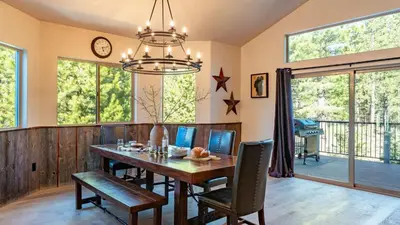 a dining room with a wooden table and chairs at 10mins to Lake • Hot Tub Game Room Forest Views Meyers Meadow by AvantStay in South Lake Tahoe