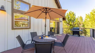 a patio with a table with an umbrella and a piano at 10mins to Lake • Hot Tub Game Room Forest Views Meyers Meadow by AvantStay in South Lake Tahoe