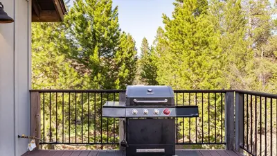 a grill sitting on a porch next to a fence at 10mins to Lake • Hot Tub Game Room Forest Views Meyers Meadow by AvantStay in South Lake Tahoe