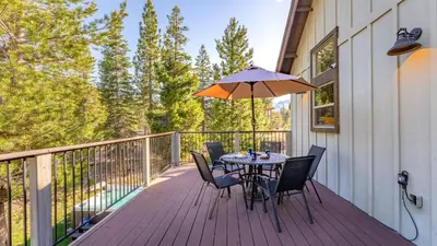 a table and chairs on a deck with an umbrella at 10mins to Lake • Hot Tub Game Room Forest Views Meyers Meadow by AvantStay in South Lake Tahoe