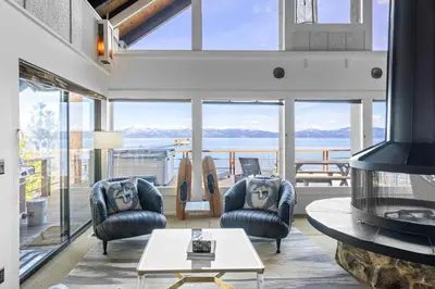 a living room with chairs and a table and windows at Towering Pines Lakefront - 3 BR w Hot Tub & Buoy in Tahoe City