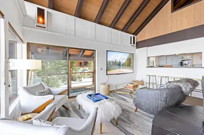 a living room with white furniture and a large window at Towering Pines Lakefront - 3 BR w Hot Tub & Buoy in Tahoe City