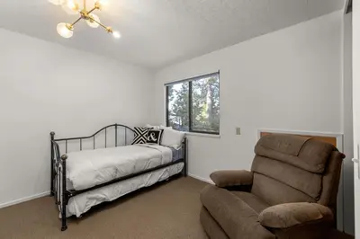 a bedroom with a bed and a chair and a window at Towering Pines Lakefront - 3 BR w Hot Tub & Buoy in Tahoe City