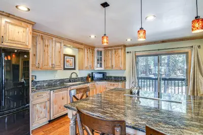 a kitchen with wooden cabinets and a large marble counter top at 1 Mi to Ski Resort South Lake Tahoe Townhome in South Lake Tahoe