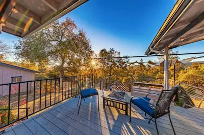 a deck with two chairs and a table at Royal Arches Cottages in Oakhurst