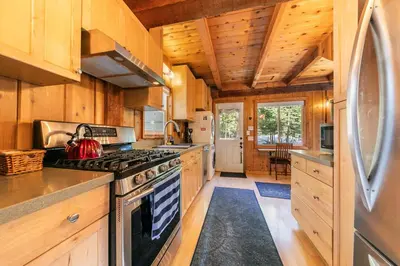 a kitchen with wooden cabinets and a stove top oven at 3BD Retreat - 5 Min to Beach Trails & Town in Carnelian Bay