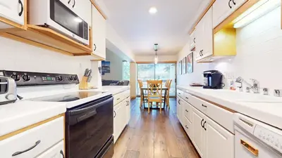 a large kitchen with white cabinets and a stove top oven at Sierra Park Road #150 condo in Mammoth Lakes