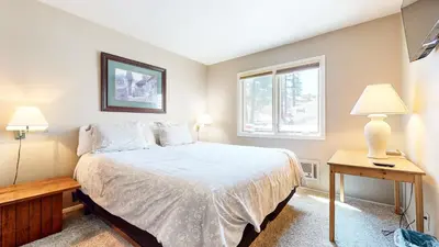 a bedroom with a bed and two lamps and a window at Lakeview Villas #27 condo in Mammoth Lakes