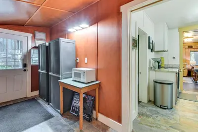a kitchen with a refrigerator and a table with a microwave at 8 Mi to Yosemite National Park Cabin with Fire Pit in Oakhurst