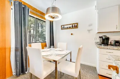 a kitchen and dining room with a table and chairs at 1 Mi to Lake Tahoe Condo with Pool Access in Kings Beach