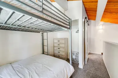 a bedroom with a loft bed and a dresser at 1 Mi to Lake Tahoe Condo with Pool Access in Kings Beach