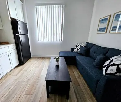 a living room with a blue couch and a table at Couple's Getaway Kitchenette Washer & Private Bath in Lincoln Village