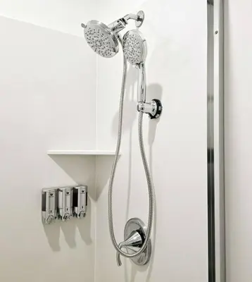 a shower with a shower head in a bathroom at Couple's Getaway Kitchenette Washer & Private Bath in Lincoln Village