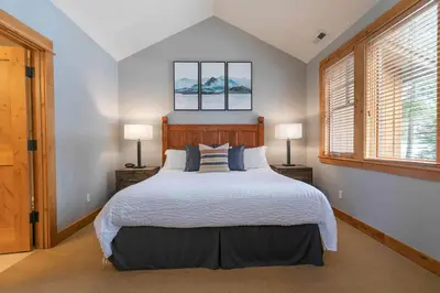 a bedroom with a large bed and two windows at The Cottages - Ski Shuttle, Ski Valet - 3-Bedroom in Truckee