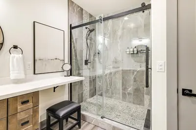 a bathroom with a glass shower with a stool at Game Room and Patio Picturesque Home in Sonora in Sonora