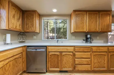 a kitchen with wooden cabinets and a window at Raven Retreat at Tahoe Donner - 3 BR w Forest Views! in Truckee