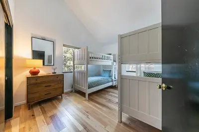 a bedroom with a bunk bed and a dresser at Raven Retreat at Tahoe Donner - 3 BR w Forest Views! in Truckee